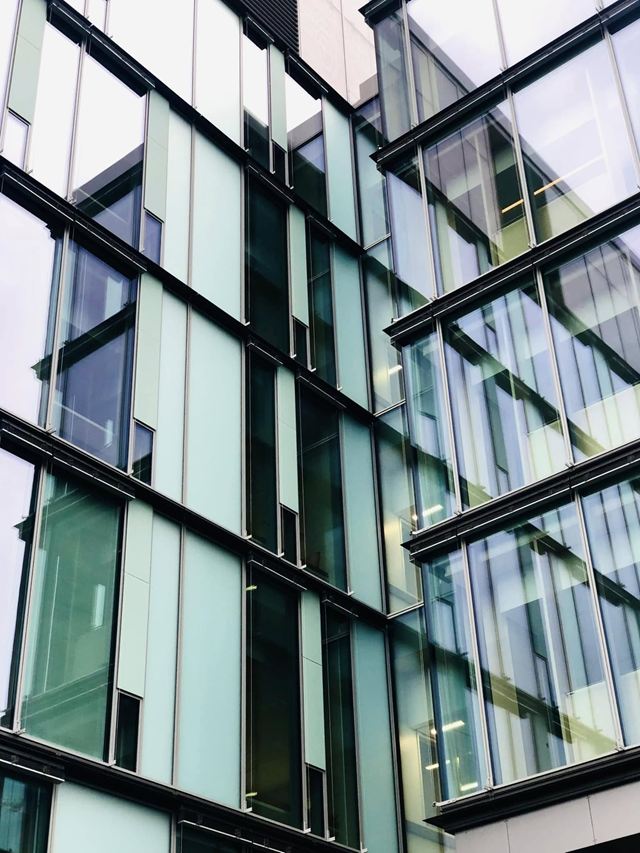 Glassfasade på et moderne bygg, fotografert skrått nedenfra.